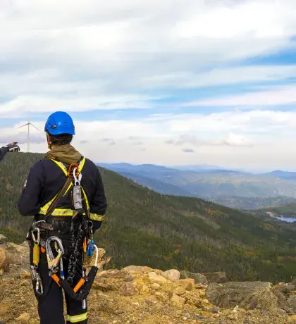 Techniciens et techniciennes face à une éolienne