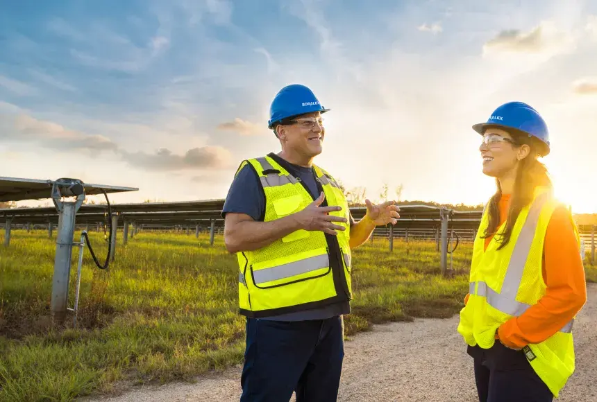 Technicien solaire discutant face à un parc solaire